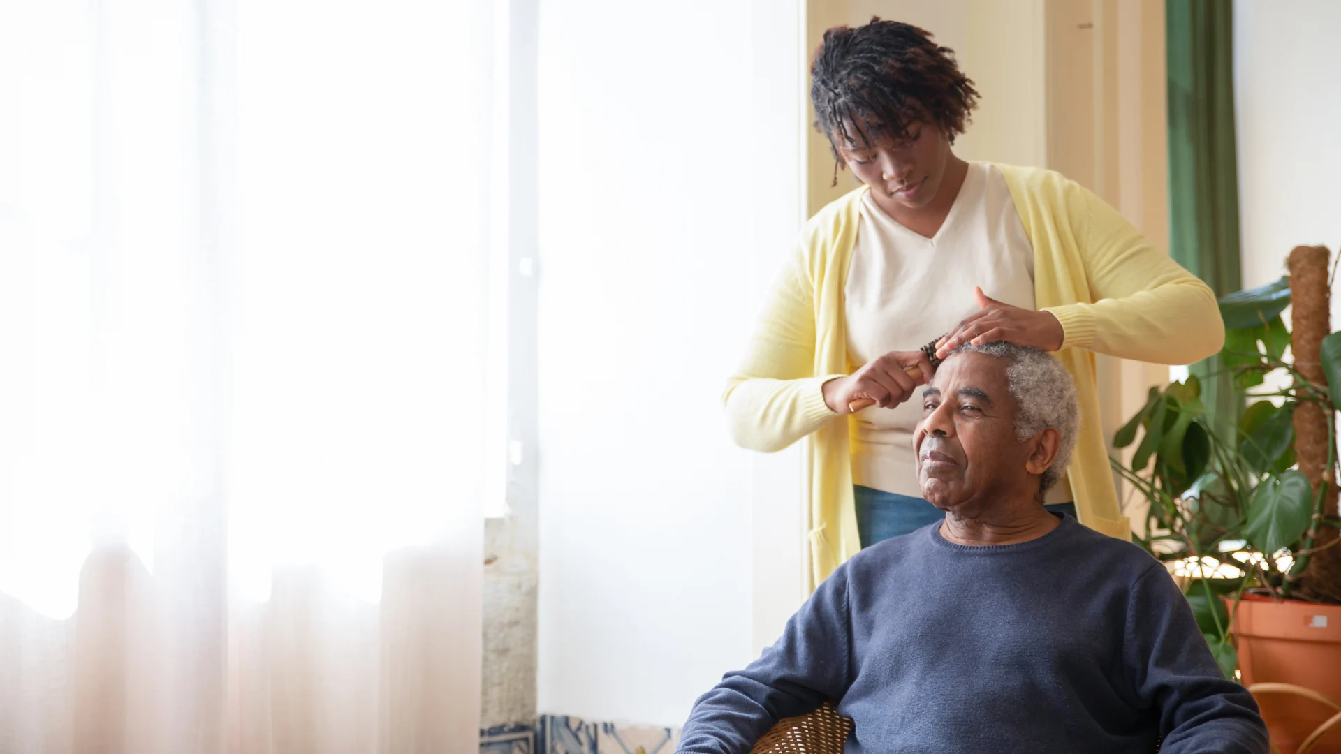 A caregiver helping an older client with personal grooming at home