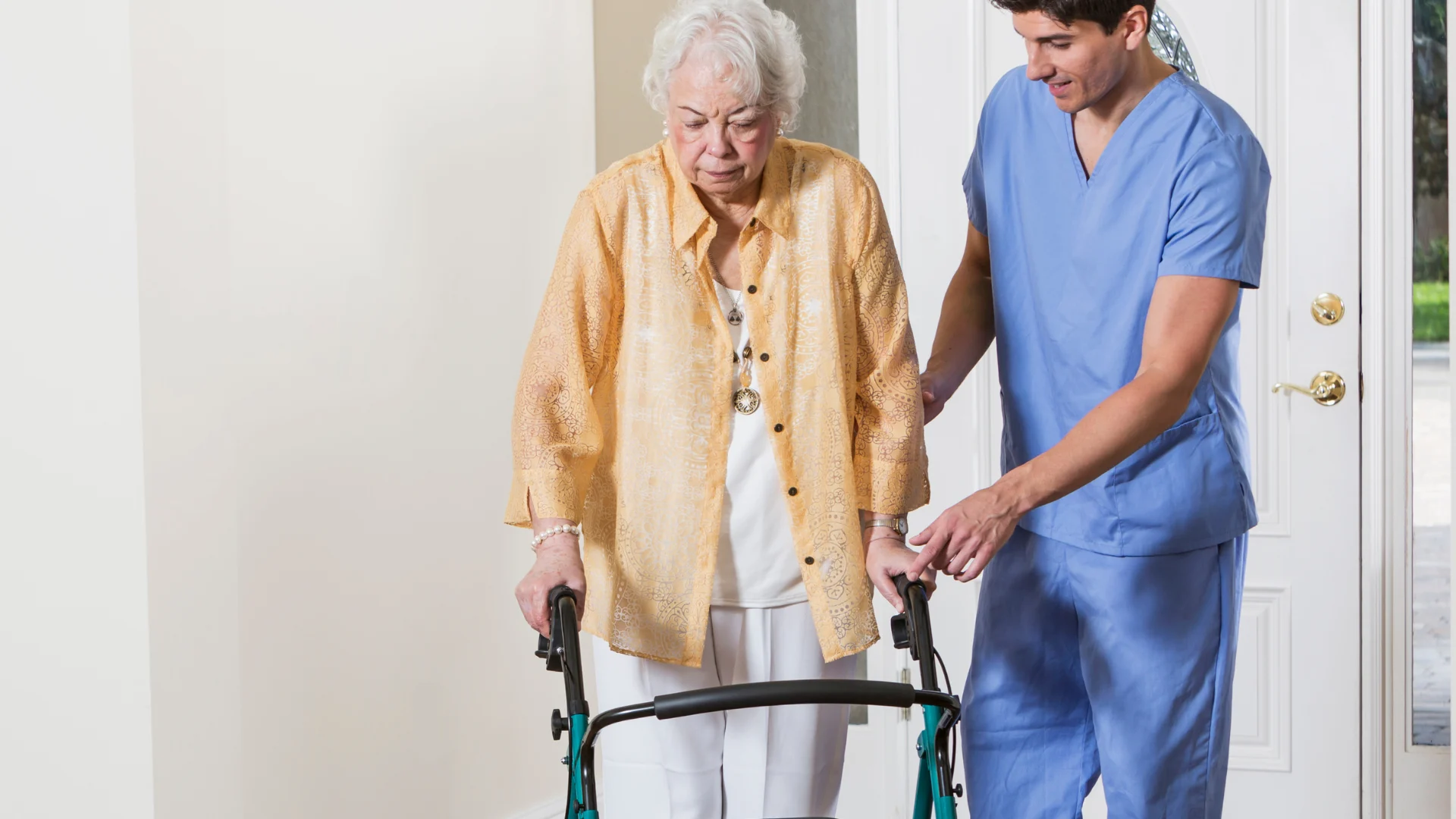 A caregiver helping an older client walk safely at home